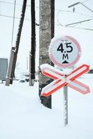 sluta. röd väg tecken är belägen på de motorväg korsning de järnväg linje i vinter- säsong foto