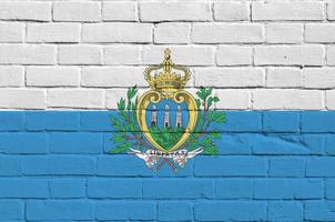 san marino flagga avbildad i måla färger på gammal tegel vägg. texturerad baner på stor tegel vägg murverk bakgrund foto