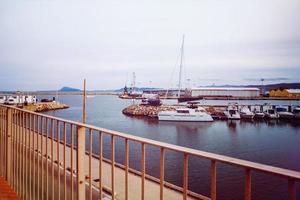 Foto från de fotgängare zon av de vågbrytare i de hamn med förtöjd yachter och fartyg i de bakgrund