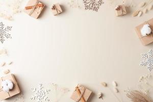 jul dekorationer med förpackning gåvor i hantverk papper och blommor på beige bakgrund. noll avfall jul Semester begrepp. platt lägga, kopia Plats foto