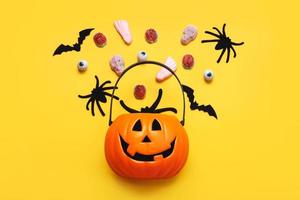 Lycklig halloween. topp se av halloween pumpa korg full av godis, fladdermöss och spindlar. halloween begrepp bakgrund foto