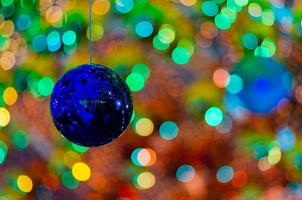 blå struntsak hängande till dekorera för jul Semester med färgrik bokeh från ljus och Övrig grannlåt. foto
