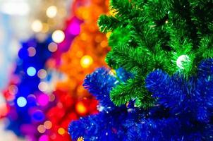selektiv fokus på grön jul träd med ljus Glödlampa och suddig fokus av färgrik jul träd. foto