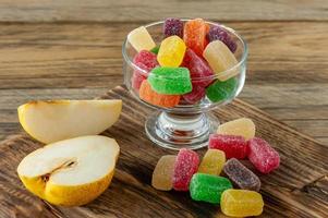 frukt marmelad sötsaker, gelé godis på en trä- skrivbord. frukt naturlig efterrätt med socker foto