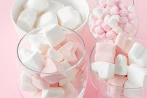marshmallow hjärta form och mini med kärlek begrepp på rosa bakgrund foto