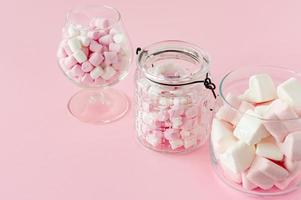 marshmallow hjärta form och mini med kärlek begrepp på rosa bakgrund foto