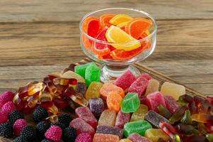 frukt marmelad sötsaker, gelé godis på en trä- skrivbord. frukt naturlig efterrätt med socker foto