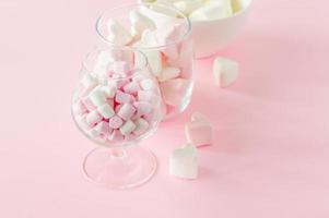 marshmallow hjärta form och mini med kärlek begrepp på rosa bakgrund foto