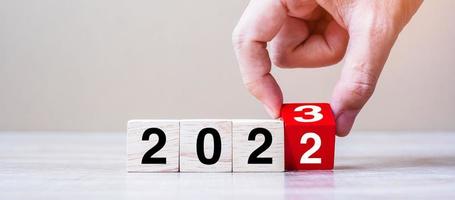 hand vända blockera 2022 till 2023 text på tabell. upplösning, strategi, planen, mål, motivering, starta om, företag och ny år Semester begrepp foto
