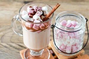 varm kakao eller choklad dryck med marshmallow i glas råna på trä- tabell. begrepp av mysigt jul och ny år högtider, kopia Plats foto