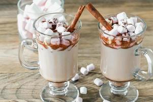 varm kakao eller choklad dryck med marshmallow i glas råna på trä- tabell. begrepp av mysigt jul och ny år högtider, kopia Plats foto