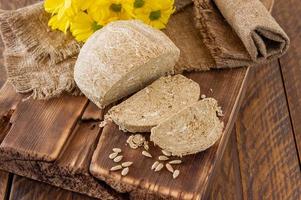 sida se av halva, orientalisk ljuv efterrätt tillverkad av jordnöt oljig frön malet till en klistra och blandad med socker sirap eras på trä- skrivbord med blommor foto