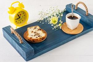 skivor av pund kaka med russin och en kopp av kaffe eras på en bricka. morgon- gott frukost foto