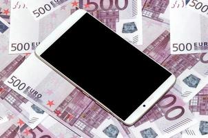 lila 500 euro pengar räkningar och en smartphone med svart skärm. kopia Plats. de begrepp av uppkopplad bank, pengar förvaltning och handla med modern teknologi foto