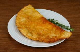 kött cheburek på tallriken och trä bakgrund foto