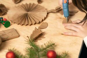 flicka gör jul träd dekorationer ut av papper med henne egen händer. steg 3. steg för steg instruktion foto
