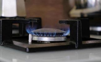närbild blå lågor av brand på en gas brännare i de kök för matlagning. gas flamma i en gas panna foto