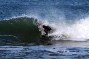 surfing på hög vågor på de medelhavs hav i nordlig israel. foto