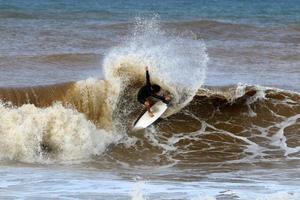 surfing på hög vågor på de medelhavs hav i nordlig israel. foto