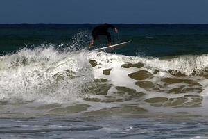 surfing på hög vågor på de medelhavs hav i nordlig israel. foto