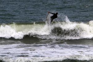 surfing på hög vågor på de medelhavs hav i nordlig israel. foto