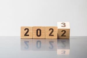 hand flip 2022 till 2023 block. mål, upplösning, strategi, plan, motivation, omstart, prognos, förändring, nedräkning och semesterkoncept för nyår foto
