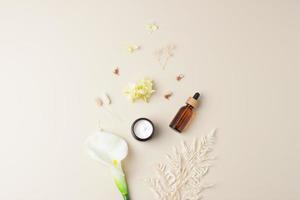 kosmetisk hud vård Produkter med blommor på pastell beige bakgrund. platt lägga, kopia Plats foto