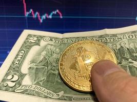 bitcoin mynt på papper räkningen två dollar, USD - suddig bakgrund. de elektronisk schema av bitcoin foto