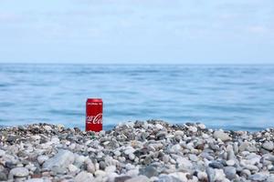 antalya, Kalkon - Maj 18, 2021 original- coca cola röd tenn kan lögner på små runda sten stenar stänga till hav Strand. Coca Cola på turkiska strand foto