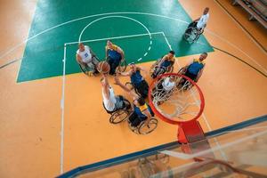 Inaktiverad krig eller arbete veteraner blandad lopp och ålder basketboll lag i rullstolar spelar en Träning match i en sporter Gym hall. handikappade människor rehabilitering och inkludering begrepp. foto