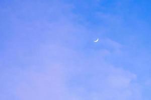 halv måne i de morgon- på mörk blå himmel, foto