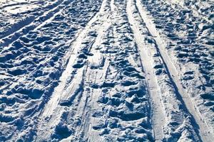 åka skidor spår i snöig fält i vinter- kväll foto