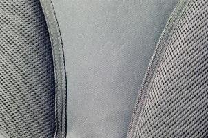 närbild av textur andningsbar maska tyg i de svart Foto ryggsäck. textur av svart plast väva väska. bakgrund bild