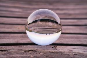 glas boll på en trä- pir på en svenska sjö på kväll timme. natur skandinavien foto