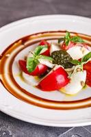 caprese sallad med mozzarella, tomat, basilika och pesto foto