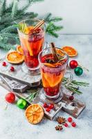 orange och tranbär drycker med orange skivor och kryddor. varm drycker för vinter- och jul foto