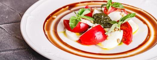 caprese sallad med mozzarella, tomat, basilika och pesto foto