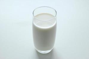 en glas av mjölk på de vit bakgrund. foto