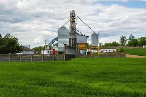 agro silos spannmålsmagasin hiss på jordbruksbearbetning tillverkning växt för bearbetning torkning rengöring och lagring av jordbruks Produkter i råg eller vete fält foto