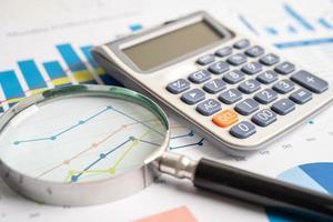 förstoringsglas på diagram diagrampapper. finansiell utveckling, bankkonto, statistik, investeringsanalys, forskningsdataekonomi, börshandel, affärskontorsföretagskoncept. foto