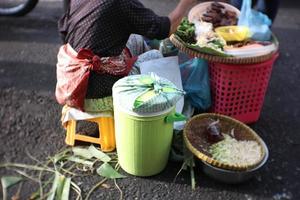 pecel ris säljare med Nej tabell, pecel ris är ris med olika grönsaker och ljuv och kryddad jordnöt sås foto