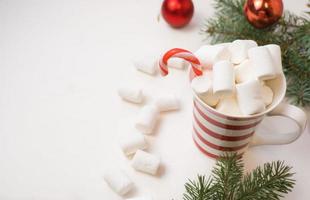 traditionell varm choklad med marshmallows och klubbor på en vit texturerad bakgrund. jul dryck tema. foto