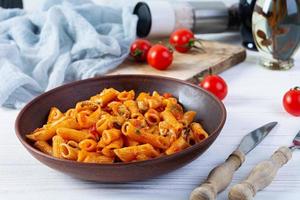 pasta penne i marinara sås med musslor, lök och persilja. klassisk italiensk pasta penne foto