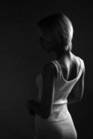 ung ledsen kvinna utseende bort, en mörk svart och vit Foto. står sidled . foto