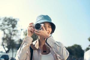 attraktiv ung vuxen asiatisk kvinna resenär som använder kameran för foto resa.