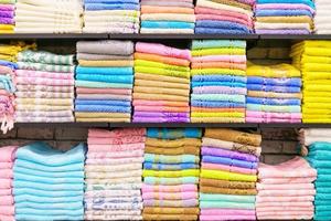Flerfärgad handdukar på hylla i marknadsföra, försäljning bomull handdukar, stack färgad bomull foto