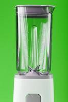 en vit blandare med ett tömma glas på en grön bakgrund. foto