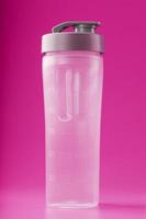 sporter smoothie flaska på rosa bakgrund, tömma. foto