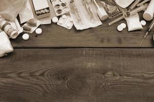 en massa av narkotisk ämnen och enheter för de förberedelse av läkemedel lögn på ett gammal trä- tabell foto