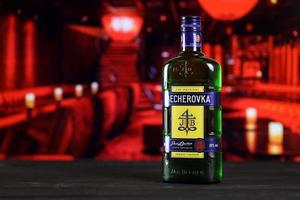 Kharkov, ukraina - februari 14, 2021 becherovka ört- likör flaska på trä- tabell med röd bar interiör på bakgrund. elit alkohol foto